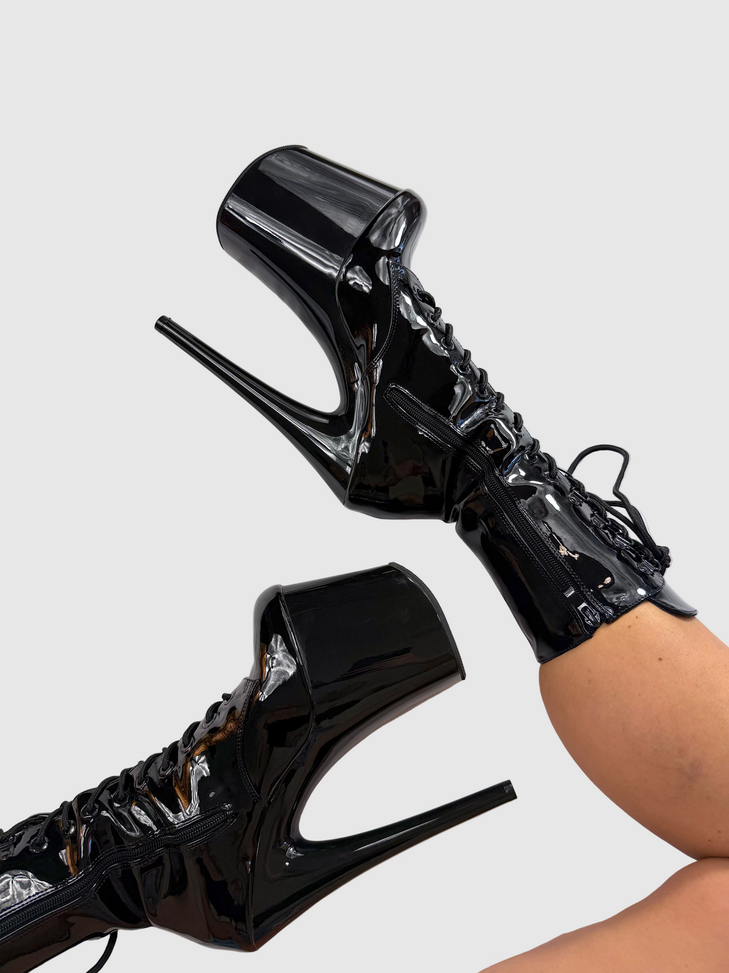 Black high-heeled shoes on a white surface