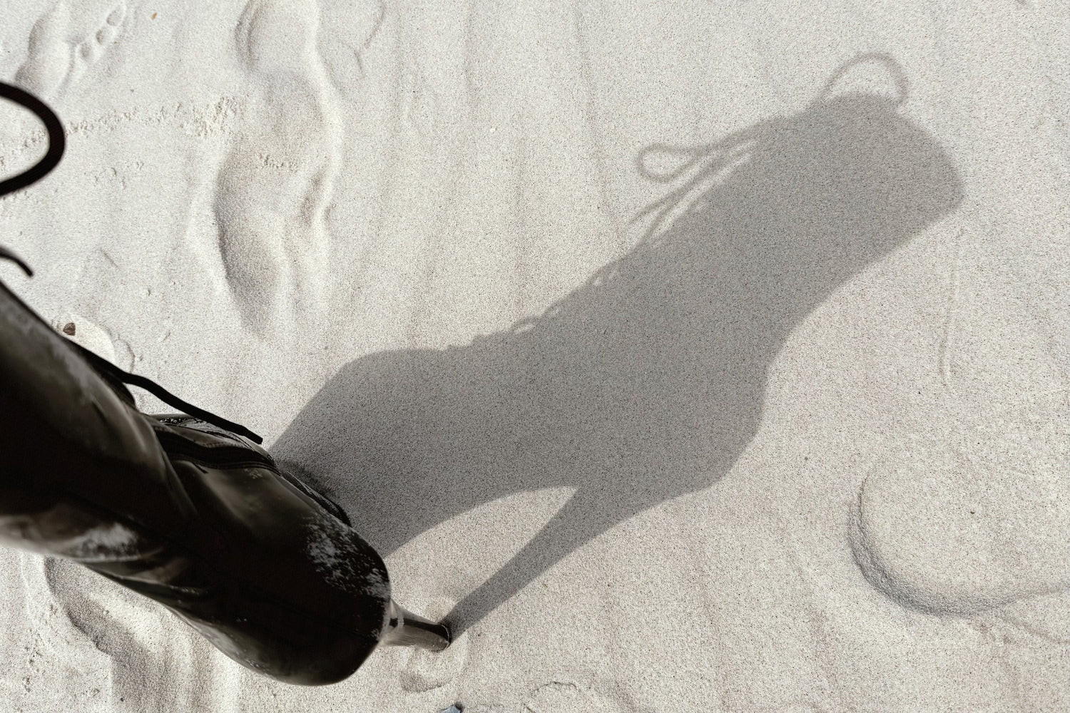 Shadow of a person walking on sand